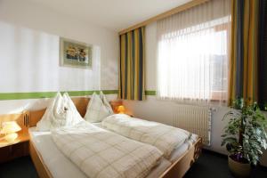 Schlafzimmer mit einem Bett und einem Fenster in der Unterkunft Landhaus Heim in Kirchberg in Tirol