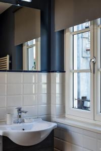 a bathroom with a sink and a mirror and a window at La Tosca Rooms in Lucca