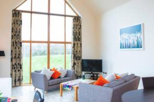 a living room with two couches and a large window at Clovenstone Lodges in Inverurie