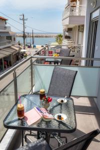 a table with two drinks on top of a balcony at Passas Inn Luxury Living in Limenaria
