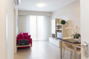 salon z czerwoną kanapą i biurkiem w obiekcie City Residence w mieście Perugia