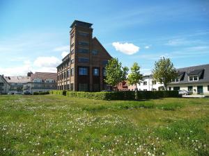 un edificio alto de ladrillo en un campo de hierba en Loft De Mar Schlossinsel, en Wolgast