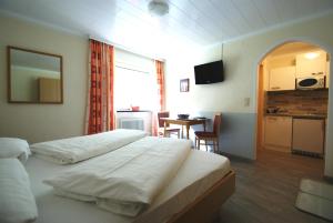 a hotel room with two beds and a kitchen and a table at "Apart Elisabeth" inkl Silvretta Premium Summercard in See