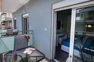 a balcony with a table and chairs and a bed at Passas Inn Luxury Living in Limenaria