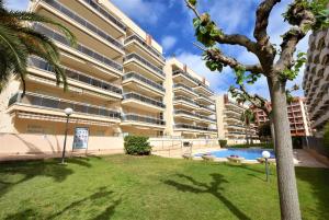 ein Apartmentgebäude mit einem Pool und einer Palme in der Unterkunft Ventura Park B4 in Salou