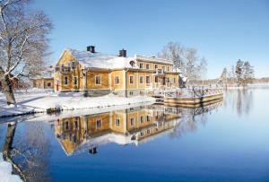 a house on the water with snow on it at Dufweholms Herrgård in Katrineholm