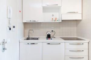 kuchnia z białymi szafkami i zlewem w obiekcie City Residence w mieście Perugia