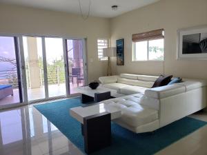 a living room with a white couch and tables at Villa Indigo Sunny 1BR Apartment in Private Gated Estate in Charlotte Amalie