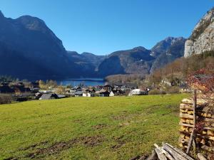 a village with a lake and mountains in the background at Seeblick Krippenstein in Obertraun