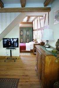 een slaapkamer met een bed en een tv in een kamer bij Gîtes les bains in Riquewihr