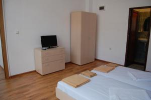 1 dormitorio con 1 cama y vestidor con TV en The White House, en Karlovo