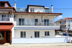 un edificio bianco con balcone sopra di Dream Apartments a Paralia Dionysiou