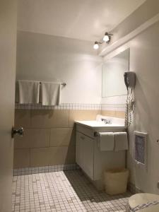 a bathroom with a sink and a mirror at Coastal Inn Digby in Digby