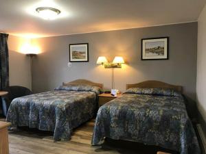 a hotel room with two beds and two lamps at Coastal Inn Digby in Digby