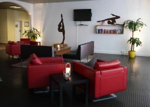 sala de estar con sofás rojos y TV en RTB-Hotel - Sportschule, en Bergisch Gladbach