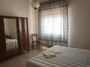 1 dormitorio con cama, espejo y ventana en Palazzo Azelio b&b, en Castiglione del Lago
