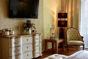 um quarto com uma cómoda e uma televisão na parede em Wellnessgarten-Hotel em Waging am See