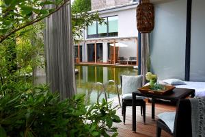 sala de estar con mesa y vistas a la piscina en Wellnessgarten-Hotel, en Waging am See