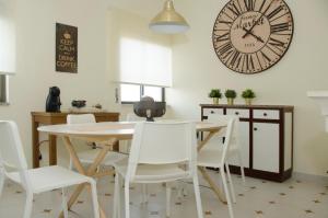 una sala da pranzo con tavolo, sedie e orologio di Casa do Relógio a Lousã