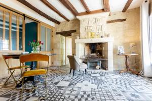- un salon avec une cheminée, une table et des chaises dans l'établissement Les Terrasses Suite et Loft de Campagne, à Avon-les-Roches