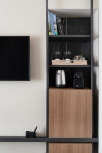 a book shelf with a tv in a room at Della Spiga Suites by Brera Apartments in Milan