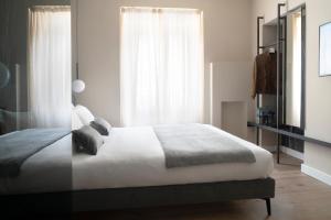 米蘭的住宿－Della Spiga Suites by Brera Apartments，卧室配有白色的床和窗户。