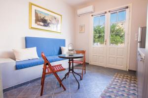 a living room with a blue couch and a table at Finiki Studios in Karpathos