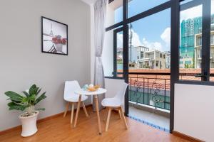 a room with a table and chairs and a balcony at Cozrum Homes Lý Chính Thắng in Ho Chi Minh City