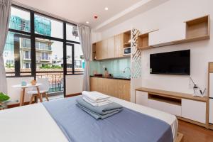 a bedroom with a large bed and a tv at Cozrum Homes Lý Chính Thắng in Ho Chi Minh City