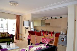 sala de estar y cocina con mesa y sillas en Apartment View Asilah Marina Golf, en Asilah