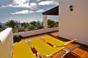een terras met gele stoelen op een balkon bij Carlos Park 51 in Playa Blanca