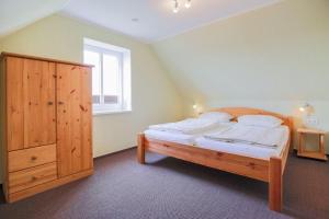 SahrensdorfにあるBuedlfarm-Sperlings-Lustのベッドルーム1室(大型ベッド1台、木製キャビネット付)