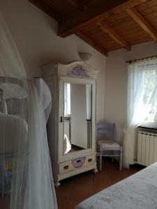 1 dormitorio con tocador y espejo. en B&B I Glicini, en Vescina