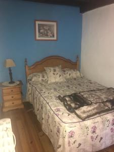 a bed in a bedroom with a blue wall at CASA RURAL LA TEYERUCA in Llanes