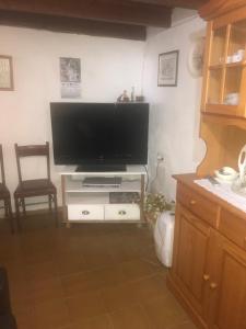 sala de estar con TV de pantalla plana en un centro de entretenimiento blanco en CASA RURAL LA TEYERUCA, en Llanes