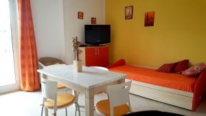 オートラントにあるAppartamento Fioreのベッド、テーブル、椅子が備わる小さな客室です。