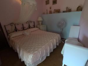 a bedroom with a bed and a fan and a chair at OLD FARM HOUSE in Riomaggiore