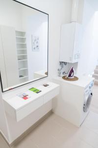 een witte badkamer met een wastafel en een spiegel bij Luxury Suites Liechtenstein in Wenen