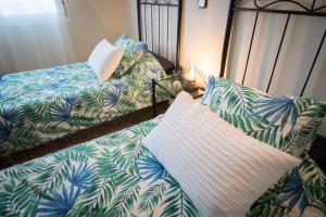 1 dormitorio con 2 camas y 1 cama con hojas de palmera en Villa La Tuna en Benalmádena