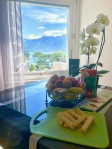 a table with a plate of food and a bowl of fruit at Lake & Mountain View Apartment I 27 in Montreux