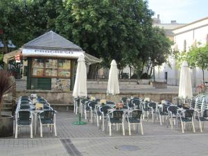 
a patio area with tables, chairs and umbrellas at Hostal Linares in Ribadeo
