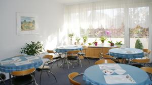 a room with blue tables and chairs and a window at Bürgerhaus in Steinbach im Taunus