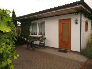 a woman sitting at a table in front of a house at Ruegen_Fewo 63 in Garz-Rügen