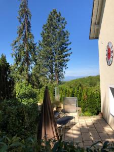 eine Terrasse mit einem Tisch, Stühlen und Bäumen in der Unterkunft Villa Adagio in Badenweiler