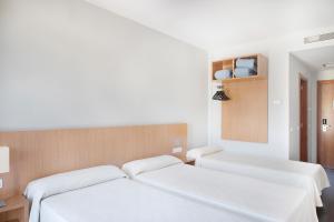 2 camas en una habitación con paredes blancas en AS Hoteles Ponferrada en Columbrianos