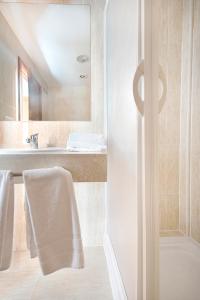 a white bathroom with a sink and a mirror at AS Hoteles Ponferrada in Columbrianos