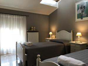 ペスキエーラ・デル・ガルダにあるAnfite Apartments Castellettoのベッドルーム1室(ベッド2台、窓付)