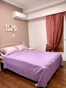 Athena's Home, Sunny Balkony 100m from metro! في أثينا: غرفة نوم مع سرير مع ملاءات أرجوانية ونافذة