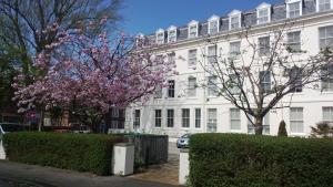 a white building with a flowering tree in front of it at Easby Hall 22 in Scarborough