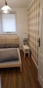 Schlafzimmer mit einem Bett, einem Fenster und einem Tisch in der Unterkunft Próchnika 49 Rooms in Łódź